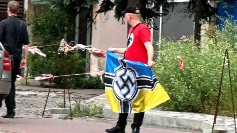 У центрі Києва чоловік розгорнув жовто-синій прапор зі свастикою